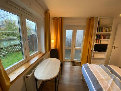 a bedroom with a table and a bed and a window at Thames Side Flat in Oxford
