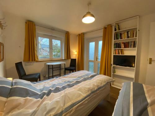 a bedroom with a bed and a table and a window at Thames Side Flat in Oxford