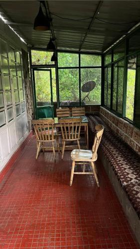 a screened in porch with a table and chairs at Stone Villa Vagamon in Vagamon