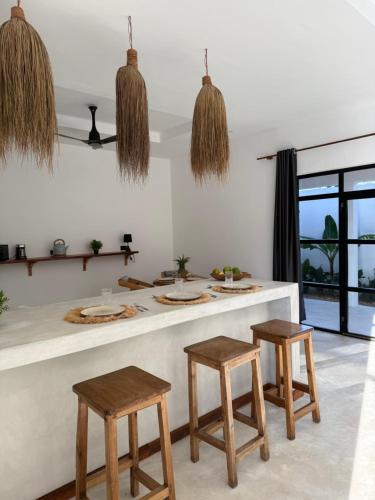 eine Küche mit einer Theke mit zwei Stühlen in der Unterkunft 3 bedroom villa with private pool in Nungwi