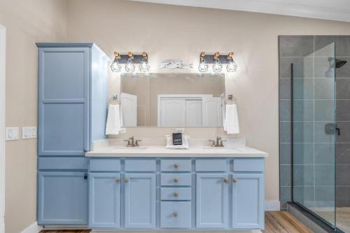 Un baño azul con lavabo y espejo. en Captain's Cove ~Waterfront Home with Pool & 75' Dock, en Marathon