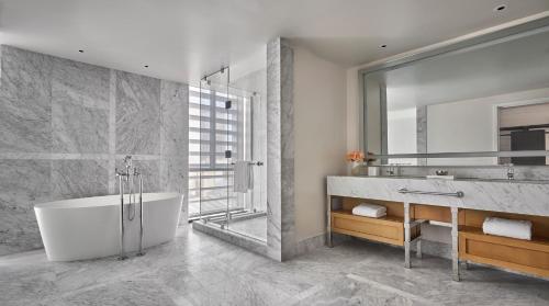 a bathroom with a tub and a sink and a mirror at Four Seasons New Orleans in New Orleans