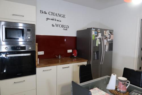 a kitchen with a microwave and a refrigerator at Chambre privée dans bel appartement lumineux in Lyon