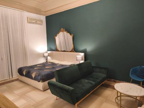 a bedroom with a bed and a green couch at Visconti apartment and Spa in Catania