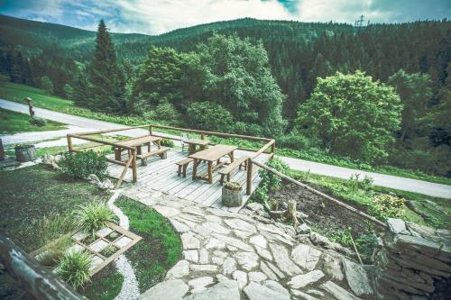a picnic table and bench on top of a hill at Horská chata Jonáš in Dolní Malá Úpa