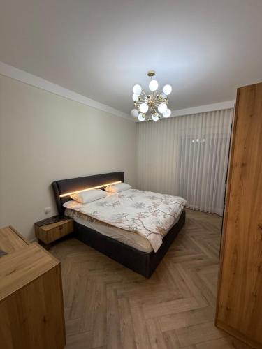 ein Schlafzimmer mit einem Bett und einem Kronleuchter in der Unterkunft Luxury Penthouse in Ferizaj