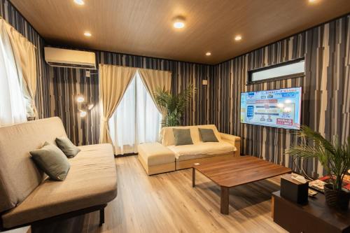 a living room with a couch and a table at 貸切新築ヴィラ l 最大9名 l 小田原城徒歩14分 l 無料P l 箱根板橋駅徒歩9分 l SENU VILLA Minamicho - Odawara in Odawara