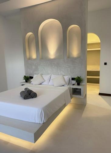 a bedroom with a large white bed with two towels on it at Villa Jena 3 bedroom private pool in Nungwi