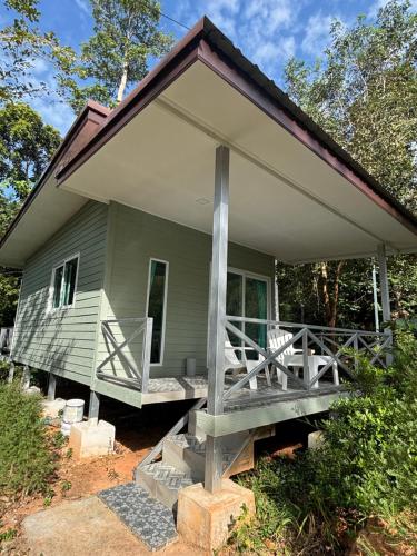 a small green house with a large porch on it at Little Bailan Retreat - Garden & River Side in Ban Bang Bao