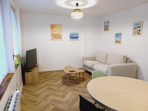a living room with a couch and a table at Escale au Nord in Dunkerque