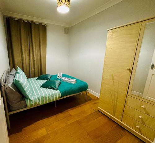 a small room with a bed and a closet at Emerald Room - shared bathroom in Ponders End
