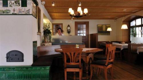 Hotel Krone في فانجن ان دير اري: غرفة طعام مع طاولة وكراسي وامرأة