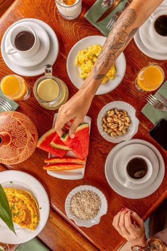 ein Tisch voller Essen und eine Person, die das Essen zubereitet. in der Unterkunft Hotel Ilha do Marajó by Unna in Soure