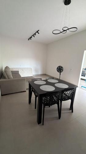 a living room with a table and a couch at Casa aconchegante com 02 quartos climatizados in Nova Mutum