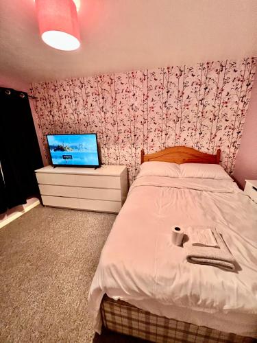 a bedroom with a bed and a tv on a wall at Mona in Hull