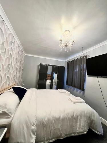a bedroom with a white bed and a chandelier at Mona in Hull