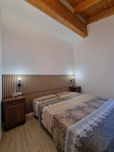 een slaapkamer met een groot bed en een houten plafond bij M&M apartments in Monclassico