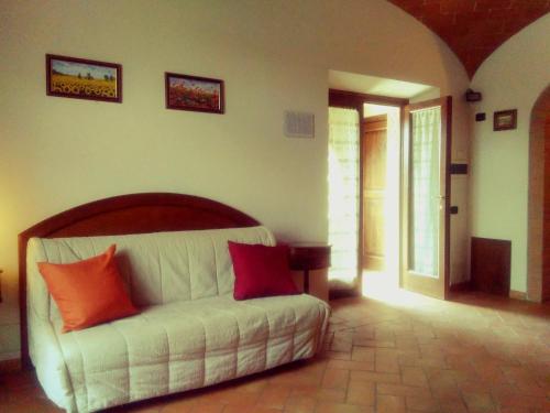 a bedroom with a white bed with red pillows on it at Casa ai Carfini in Poggibonsi