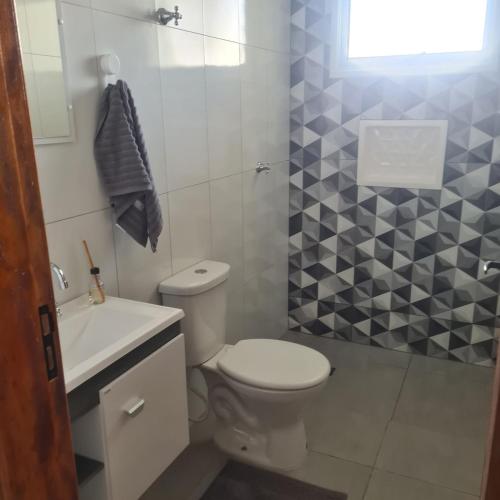 a bathroom with a white toilet and a sink at Casa 1 Montebelle in Porangaba