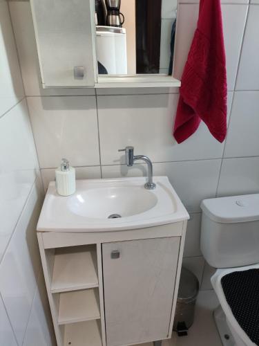 a bathroom with a sink and a toilet at Loft Praia da Vila in Imbituba