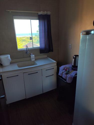 a kitchen with a sink and a window at Loft Praia da Vila in Imbituba
