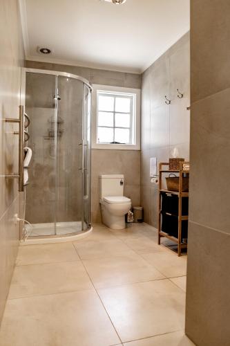 a bathroom with a shower and a toilet at Kiama Tea House in Bicheno