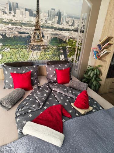 a bed with red pillows in front of the eiffel tower at Velvita Central in Sliven