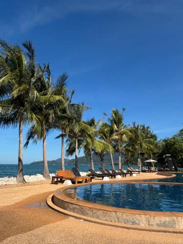 ein Swimmingpool an einem Strand mit Palmen in der Unterkunft House Sea Front view - Swimming Pool in Ko Chang