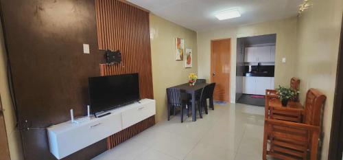 un soggiorno con TV a schermo piatto e una cucina di Welcome Home - VCDU Riverview 