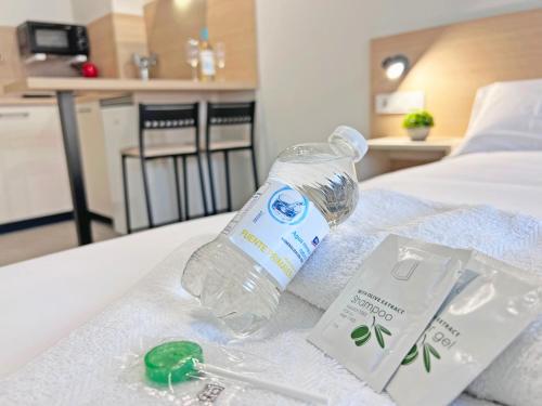 a bottle of water sitting on top of a bed at NUEVO -Bogotá Suites- Apartamentos con cocina, AC, 15min del centro a pie in Alicante