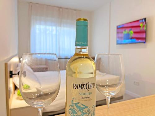 a bottle of wine sitting next to two wine glasses at NUEVO -Bogotá Suites- Apartamentos con cocina, AC, 15min del centro a pie in Alicante