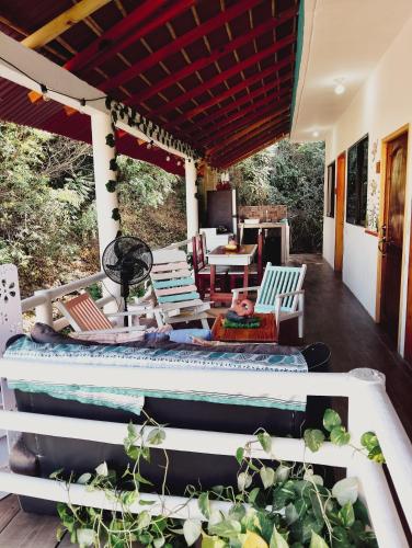 a porch with chairs and a table and a couch at Posada Casa Tortuga, Zipolite in Zipolite