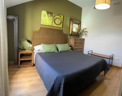 a bedroom with a bed and a clock on the wall at Apartamentos Alcazar de Baeza in Baeza