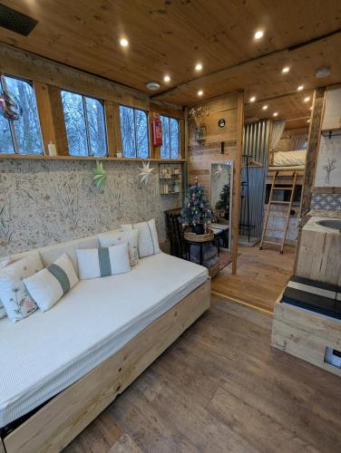 Un dormitorio con una cama en una habitación con ventanas. en The Horsebox at Wits End, en Hartford
