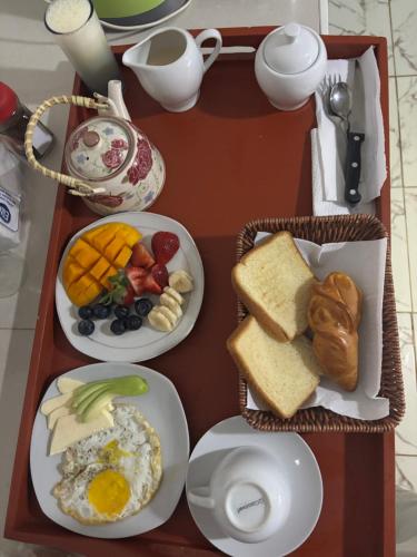 een dienblad met borden ontbijtproducten erop bij Thalu House in Pacasmayo