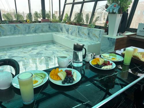 een tafel met borden met eten en drinken erop bij Thalu House in Pacasmayo