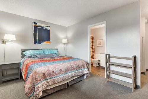 een slaapkamer met een bed en een badkamer bij Second-floor - Riverfront Condo Near Downtown Bend in Bend