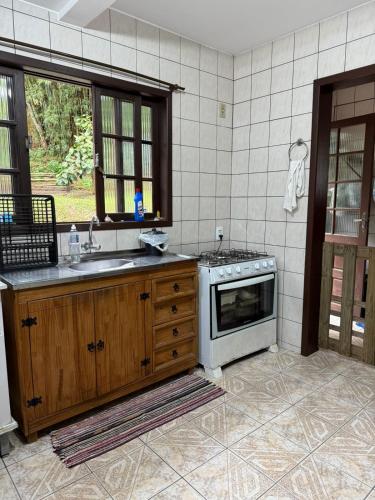 a kitchen with a sink and a stove at Interior beach house in Bombinhas! in Bombinhas