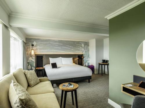 a hotel room with a bed and a couch at Mercure Bedford Centre Hotel in Bedford