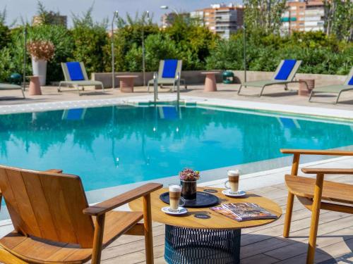 a table and chairs next to a swimming pool at Ibis Styles Madrid City Las Ventas in Madrid