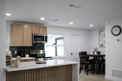 a kitchen and dining room with a table and a clock at Spacious Casselberry Home Near Attractions in Orlando