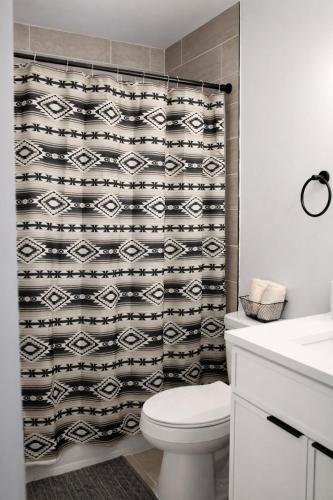 a bathroom with a toilet and a shower curtain at Spacious Casselberry Home Near Attractions in Orlando