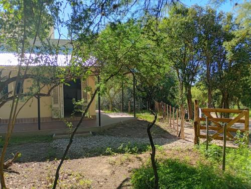ein Garten mit einer Holzbank vor einem Gebäude in der Unterkunft Tacuarita in Los Hornillos