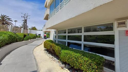 een gebouw met struiken naast een stoep bij Serena Mar La Serena in La Serena