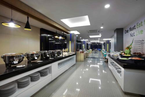 a restaurant with a buffet line with plates and food at Cordela Kartika Dewi Yogyakarta in Yogyakarta