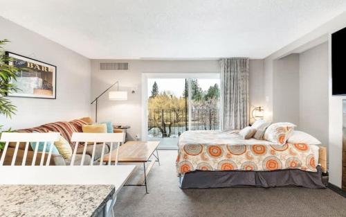ein Schlafzimmer mit Bett und ein Wohnzimmer in der Unterkunft River View Condo- Edge of Downtown in Bend