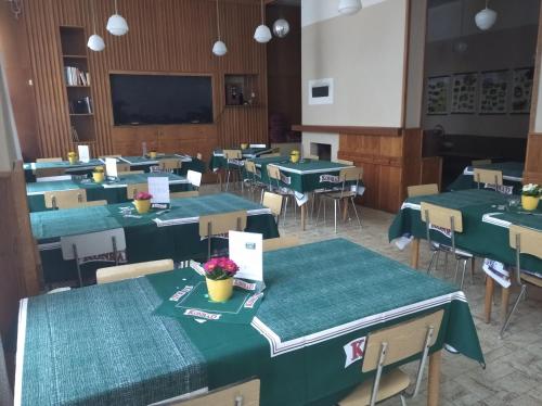 a classroom with green tables and chairs and a screen at Penzion Koniklec in Jestrabi V Krkonosich