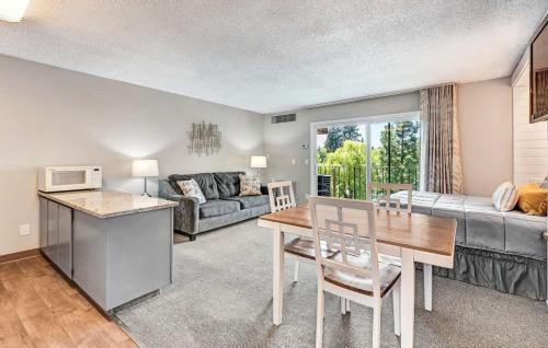 ein Wohnzimmer mit einem Tisch und einem Sofa in der Unterkunft Riverfront Condo - Pet Friendly Near Downtown in Bend