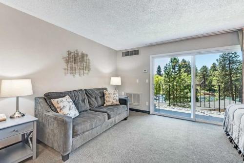 ein Wohnzimmer mit Couch und großem Fenster in der Unterkunft Riverfront Condo - Pet Friendly Near Downtown in Bend