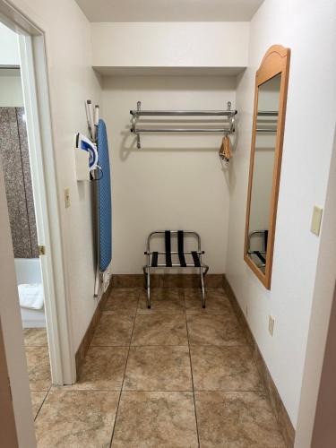 a walk in closet with a chair and a mirror at Blue Bonnet Suites -Lubbock, TX - Medical Center in Lubbock